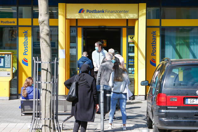 22.04.2020, xtgx, Maskenpflicht in Wolfsburg, Menschen warten vor einer Filiale der Deutschen Post. Die Stadt Wolfsburg hat ab dieser Woche eine Maskenpflicht im Nahverkehr, in oeffentlichen Gebauden und Geschaeften eingefuehrt. Dort muss jeder Fahrgast oder Besucher Mund und Nase mit einer Maske bedecken. Symbolfoto, Symbolbild, Risikogruppe, Senioren, Schutzmaske, Gesichtsmaske, Mund-Nasen-Maske. Wolfsburg