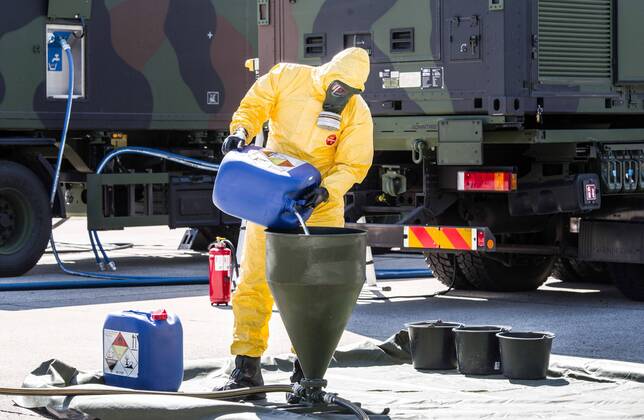 April 22, 2020, Neubiberg Bei Muenchen, Bavaria, Germany: German Bundeswehr soldiers wear gas masks and Dupint TyChem C protective clothing while mixing the constituents together to make Oxicide, a surface disinfectant used in the fight against Coronavirus. At the Bundeswehr Universitaet (Military University of Germany) in Neubiberg near Munich, Bavarian Interior Minister Joachim Herrmann, Generalleutnant Martin Schelleis, dem Nationalen Territorialen Befehlshaber und Inspekteur der Streitkro¤ftebasis, as well as members of the Technisches Hilfswerk (Federal Agency for Technical Relief) were on hand to explain the effort and coordination of the production of large amounts of surface disinfectants used to help in the fight against SARS-CoV-2 Coronavirus. Germany is currently at 148,174 positive diagnoses with 4,961 deaths. Neubiberg Be - ZUMAb160 20200422_zbp_b160_046 Copyright: xSachellexBabbarx