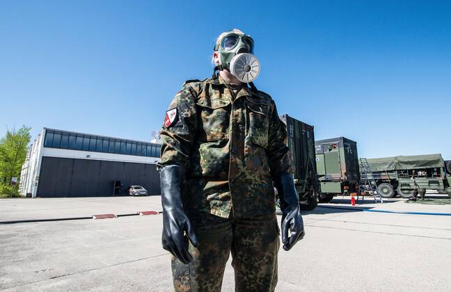 April 22, 2020, Neubiberg Bei Muenchen, Bavaria, Germany: German Bundeswehr soldiers wear gas masks and Dupint TyChem C protective clothing while mixing the constituents together to make Oxicide, a surface disinfectant used in the fight against Coronavirus. At the Bundeswehr Universitaet (Military University of Germany) in Neubiberg near Munich, Bavarian Interior Minister Joachim Herrmann, Generalleutnant Martin Schelleis, dem Nationalen Territorialen Befehlshaber und Inspekteur der Streitkro¤ftebasis, as well as members of the Technisches Hilfswerk (Federal Agency for Technical Relief) were on hand to explain the effort and coordination of the production of large amounts of surface disinfectants used to help in the fight against SARS-CoV-2 Coronavirus. Germany is currently at 148,174 positive diagnoses with 4,961 deaths. Neubiberg Be - ZUMAb160 20200422_zbp_b160_077 Copyright: xSachellexBabbarx