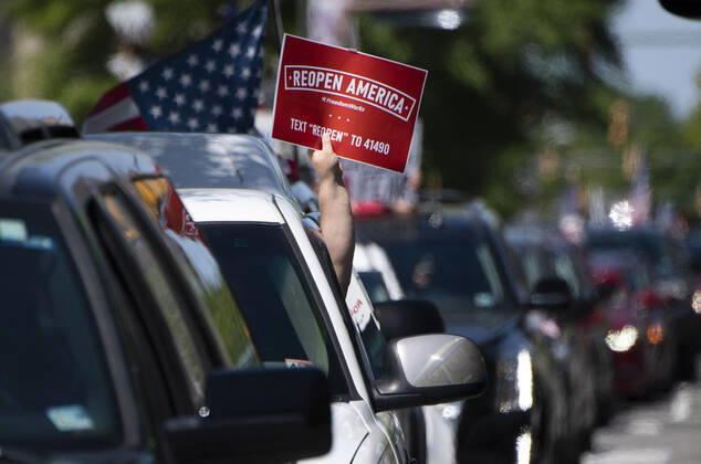 Protesters demonstrate from the vehicles as they call on Gov. Ralph Northam to reopen Virginia and end executive order 53 with bans gatherings of over 10 in the midst of the Coronavirus COVID-19 pandemic, near the State Capitol Building in Richmond, Virginia on Wednesday, April 22, 2020. The group is urging the reopening of business despite the COVID-19 pandemic still infecting the nation.  WAP20200422301 KEVINxDIETSCH