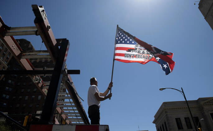 A man demonstrates from his vehicles as he and others call on Gov. Ralph Northam to reopen Virginia and end executive order 53 with bans gatherings of over 10 in the midst of the Coronavirus COVID-19 pandemic, near the State Capitol Building in Richmond, Virginia on Wednesday, April 22, 2020. The group is urging the reopening of business despite the COVID-19 pandemic still infecting the nation.  WAP20200422306 KEVINxDIETSCH