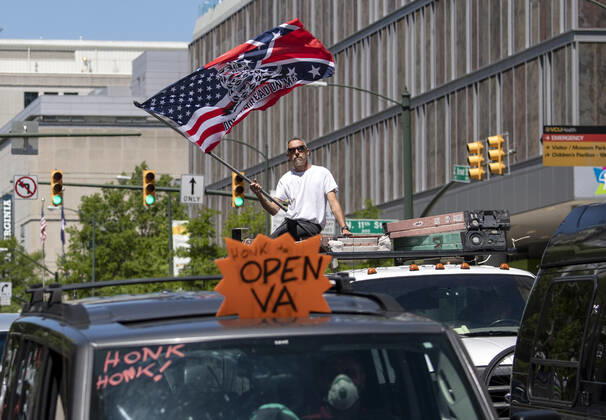 Protesters demonstrate from the vehicles as they call on Gov. Ralph Northam to reopen Virginia and end executive order 53 with bans gatherings of over 10 in the midst of the Coronavirus COVID-19 pandemic, near the State Capitol Building in Richmond, Virginia on Wednesday, April 22, 2020. The group is urging the reopening of business despite the COVID-19 pandemic still infecting the nation.  WAP20200422307 KEVINxDIETSCH