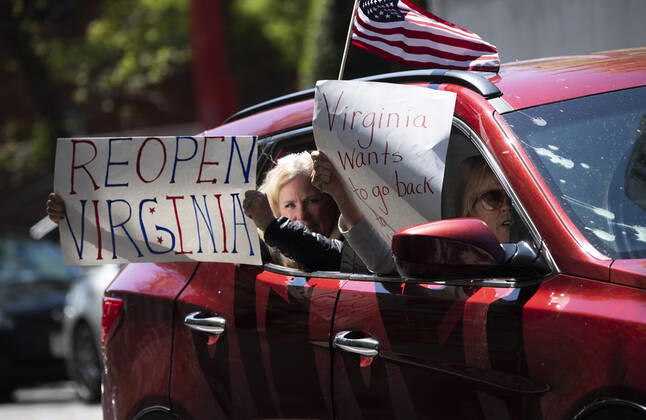 Protesters demonstrate from the vehicles as they call on Gov. Ralph Northam to reopen Virginia and end executive order 53 with bans gatherings of over 10 in the midst of the Coronavirus COVID-19 pandemic, near the State Capitol Building in Richmond, Virginia on Wednesday, April 22, 2020. The group is urging the reopening of business despite the COVID-19 pandemic still infecting the nation.  WAP20200422321 KEVINxDIETSCH