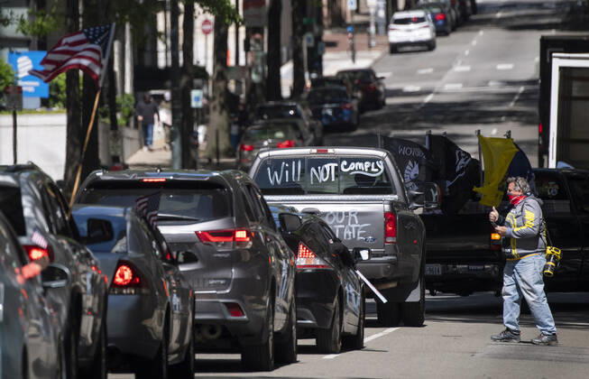 Protesters demonstrate from the vehicles as they call on Gov. Ralph Northam to reopen Virginia and end executive order 53 with bans gatherings of over 10 in the midst of the Coronavirus COVID-19 pandemic, near the State Capitol Building in Richmond, Virginia on Wednesday, April 22, 2020. The group is urging the reopening of business despite the COVID-19 pandemic still infecting the nation.  WAP20200422322 KEVINxDIETSCH