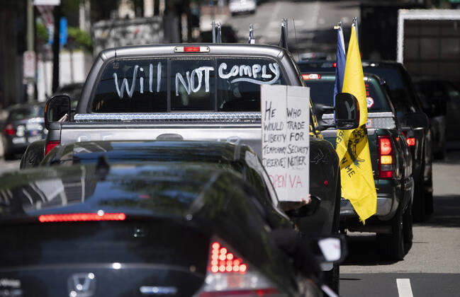 Protesters demonstrate from the vehicles as they call on Gov. Ralph Northam to reopen Virginia and end executive order 53 with bans gatherings of over 10 in the midst of the Coronavirus COVID-19 pandemic, near the State Capitol Building in Richmond, Virginia on Wednesday, April 22, 2020. The group is urging the reopening of business despite the COVID-19 pandemic still infecting the nation.  WAP20200422323 KEVINxDIETSCH