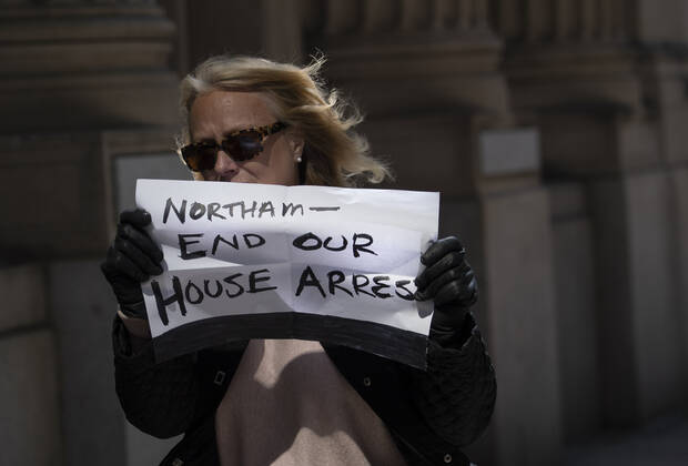 A protester participates in a rally calling on Gov. Ralph Northam to reopen Virginia and end executive order 53 with bans gatherings of over 10 in the midst of the Coronavirus COVID-19 pandemic, near the State Capitol Building in Richmond, Virginia on Wednesday, April 22, 2020. The group is urging the reopening of business despite the COVID-19 pandemic still infecting the nation.  WAP20200422324 KEVINxDIETSCH