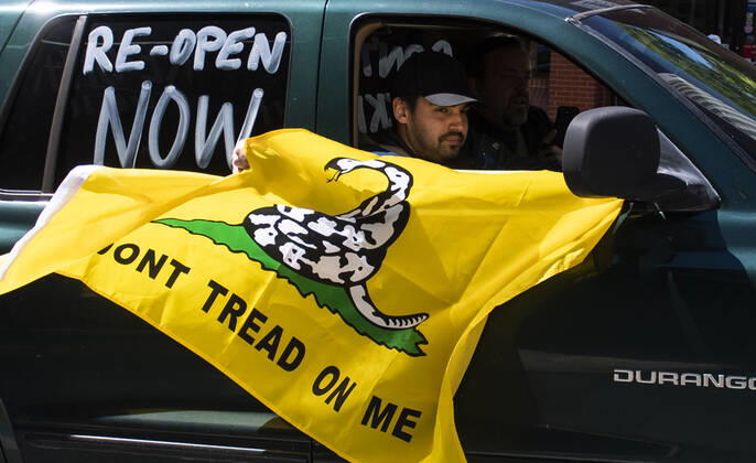 Protesters demonstrate from the vehicles as they call on Gov. Ralph Northam to reopen Virginia and end executive order 53 with bans gatherings of over 10 in the midst of the Coronavirus COVID-19 pandemic, near the State Capitol Building in Richmond, Virginia on Wednesday, April 22, 2020. The group is urging the reopening of business despite the COVID-19 pandemic still infecting the nation.  WAP20200422325 KEVINxDIETSCH