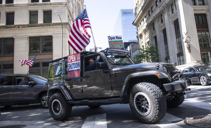 Protesters demonstrate from the vehicles as they call on Gov. Ralph Northam to reopen Virginia and end executive order 53 with bans gatherings of over 10 in the midst of the Coronavirus COVID-19 pandemic, near the State Capitol Building in Richmond, Virginia on Wednesday, April 22, 2020. The group is urging the reopening of business despite the COVID-19 pandemic still infecting the nation.  WAP20200422326 KEVINxDIETSCH