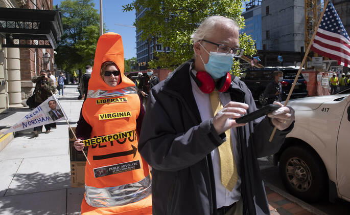 Demonstrators participate in a rally calling on Gov. Ralph Northam to reopen Virginia and end executive order 53 with bans gatherings of over 10 in the midst of the Coronavirus COVID-19 pandemic, near the State Capitol Building in Richmond, Virginia on Wednesday, April 22, 2020. The group is urging the reopening of business despite the COVID-19 pandemic still infecting the nation.  WAP20200422327 KEVINxDIETSCH