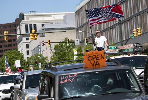 Protesters demonstrate from the vehicles as they call on Gov. Ralph Northam to reopen Virginia and end executive order 53 with bans gatherings of over 10 in the midst of the Coronavirus COVID-19 pandemic, near the State Capitol Building in Richmond, Virginia on Wednesday, April 22, 2020. The group is urging the reopening of business despite the COVID-19 pandemic still infecting the nation.  WAP20200422302 KEVINxDIETSCH