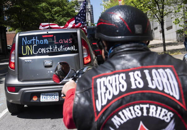 Protesters demonstrate from the vehicles as they call on Gov. Ralph Northam to reopen Virginia and end executive order 53 with bans gatherings of over 10 in the midst of the Coronavirus COVID-19 pandemic, near the State Capitol Building in Richmond, Virginia on Wednesday, April 22, 2020. The group is urging the reopening of business despite the COVID-19 pandemic still infecting the nation.  WAP20200422304 KEVINxDIETSCH