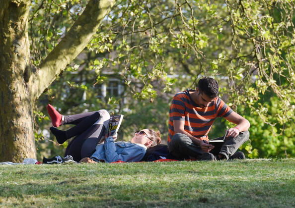. 22 04 2020. London, United Kingdom. Coronavirus crisis. A man and a woman reading on the grass at King s Stairs Gardens this afternoon, as the coronavirus lockdown continues.  xGustavoxValientex xi-Imagesx IIM-21051-0031