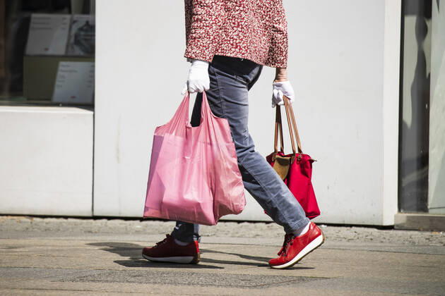 Dame mit Latex Handschuehe vor einer Vitrine von Uniqlo in Berlin am 22. April 2020. Ab heute koennen in Berlin laeden unter 800 qm, Buchhandlucngen und Autosalons wieder oeffnen mit Einhanltung von Hygiene und Distanzvorschriften. Coronavirus in Berlin