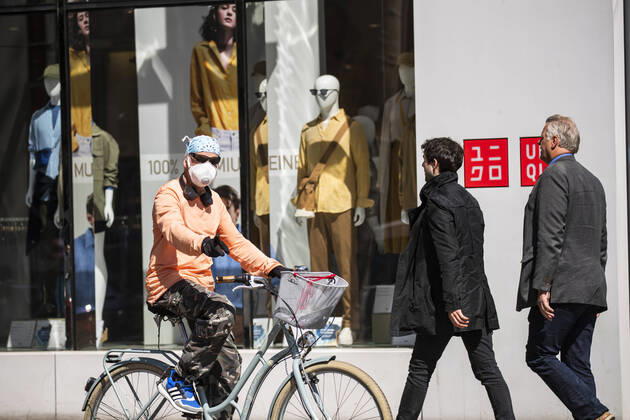 Menschen mit Mundschutzmaske vor einer Vitrine von Uniqlo in Berlin am 22. April 2020. Ab heute koennen in Berlin laeden unter 800 qm, Buchhandlucngen und Autosalons wieder oeffnen mit Einhanltung von Hygiene und Distanzvorschriften. Coronavirus in Berlin