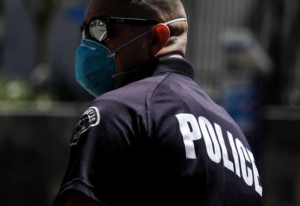 April 22, 2020, Los Angeles, California, U.S: A police officer wearing a face mask directs traffic during a vehicle caravan protest to call on state and local officials to re-open the economy during the coronavirus disease outbreak in downtown Los Angeles, Wednesday April 22, 2020. Los Angeles U.S. - ZUMAc68_ 20200422_zaf_c68_013 Copyright: xRingoxChiux