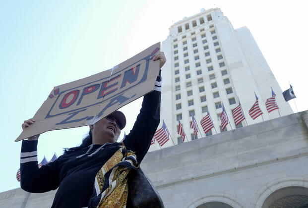 April 22, 2020, Los Angeles, California, U.S: A demonstrator holding a sign takes part a vehicle caravan protest to call on state and local officials to re-open the economy during the coronavirus disease outbreak in downtown Los Angeles, Wednesday April 22, 2020. Los Angeles U.S. - ZUMAc68_ 20200422_zaf_c68_039 Copyright: xRingoxChiux