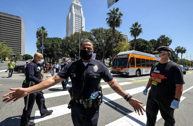 April 22, 2020, Los Angeles, California, U.S: Police officers clear the street after demonstrators blocking a street during a vehicle caravan protest to call on state and local officials to re-open the economy during the coronavirus disease outbreak in downtown Los Angeles, Wednesday April 22, 2020. Los Angeles U.S. - ZUMAc68_ 20200422_zaf_c68_044 Copyright: xRingoxChiux
