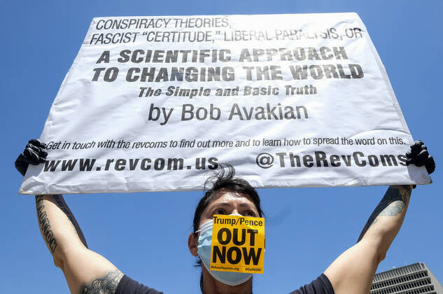 April 22, 2020, Los Angeles, California, U.S: A counter demonstrator wearing a face mask with a sign takes part a vehicle caravan protest to call on state and local officials to re-open the economy during the coronavirus disease outbreak in downtown Los Angeles, Wednesday April 22, 2020. Los Angeles U.S. - ZUMAc68_ 20200422_zaf_c68_045 Copyright: xRingoxChiux