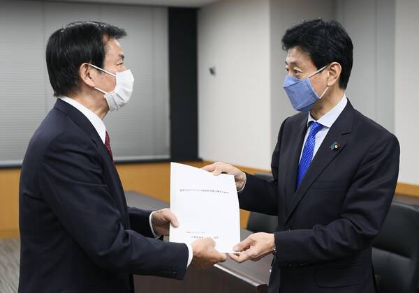 New coronavirus Chiba Gov. Kensaku Morita (L) meets Japanese economic revitalization minister Yasutoshi Nishimura in Tokyo on April 22, 2020, over the coronavirus pandemic. 