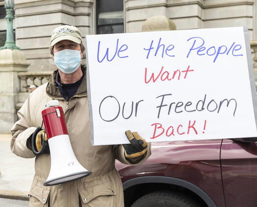 NY: Operation Gridlock in Albany A man wearing facial mask and holding poster participates in Operation Gridlock protest outside of New York State Capitol Building. Participants demanded reopening of New York State. Many people on the street disregarded wearing facial masks and keep social distances. Albany New York United States Copyright: LevxRadin