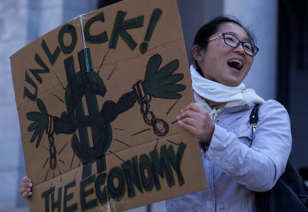 April 22, 2020, Los Angeles, California, U.S: A demonstrator holding a sign takes part a vehicle caravan protest to call on state and local officials to re-open the economy during the coronavirus disease outbreak in downtown Los Angeles, Wednesday April 22, 2020. Los Angeles USA - ZUMAc68_ 20200422_zaf_c68_009 Copyright: xRingoxChiux