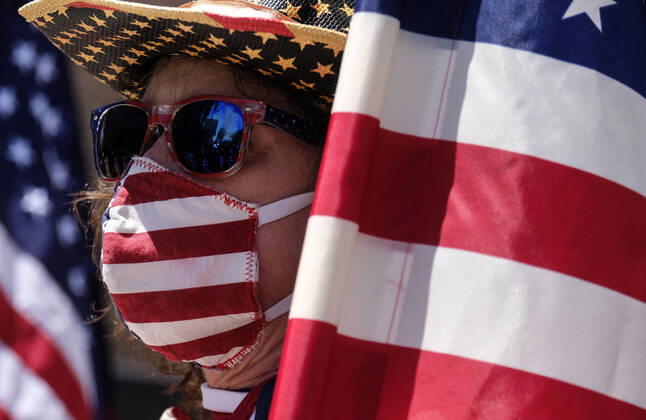 April 22, 2020, Los Angeles, California, U.S: A demonstrator wearing a face mask with the U.S. flag design takes part a vehicle caravan protest to call on state and local officials to re-open the economy during the coronavirus disease outbreak in downtown Los Angeles, Wednesday April 22, 2020. Los Angeles USA - ZUMAc68_ 20200422_zaf_c68_030 Copyright: xRingoxChiux