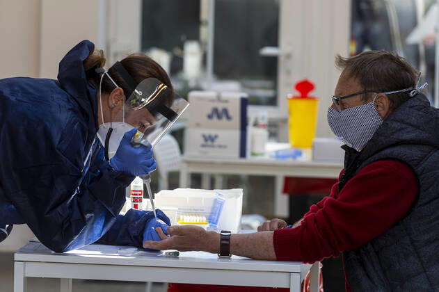 A medic takes a sample for a covid-19 test from a volunteer, on April 23, 2020, in Litomerice, Czech Republic. Across-the-board testing of population for new coronavirus began today. Test points open in Prague at 10:00, in Brno and Litomerice at 8:00. The goal is to find out the presence of coronavirus in Czech population. (CTKxPhoto OndrejxHajek) CTKPhotoP202004230261501 HAJ 02