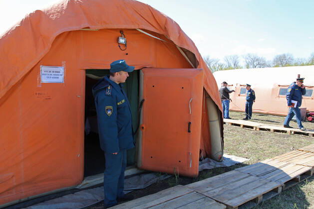 DONETSK, UKRAINE - APRIL 23, 2020: Servicemen of the Emergency Situations Ministry of the Donetsk People s Republic at a field hospital for coronavirus patients set up as part of a COVID-19 response exercise; the exercise is aimed at providing a timely and efficient professional medical assistance to victims of emergencies in case of a lack of beds in hospitals. A similar field hospital can admit over 100 people. Valentin Sprinchak TASS  TS0D6D3F