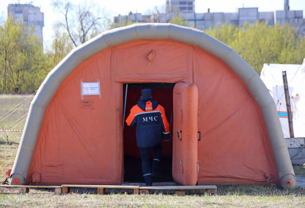 DONETSK, UKRAINE - APRIL 23, 2020: A serviceman of the Emergency Situations Ministry of the Donetsk People s Republic enters a tent at a field hospital for coronavirus patients set up as part of a COVID-19 response exercise; the exercise is aimed at providing a timely and efficient professional medical assistance to victims of emergencies in case of a lack of beds in hospitals. A similar field hospital can admit over 100 people. Valentin Sprinchak TASS  TS0D6D39