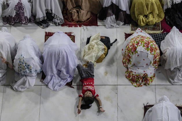 April 23, 2020, Lhokseumawe, Aceh, Indonesia: A girl sleeps among Muslim women who perform the first tarawih prayer on the holy month of Ramadan without applying social distancing amid concerns of coronavirus disease (COVID-19) at a Mosque in Lhokseumawe, Aceh province. During the fasting month of Ramadan, Muslims around the world do not eat, drink, smoke, and have sex from the sunrise to sunset. Lhokseumawe Indonesia - ZUMAm250 20200423_zip_m250_001 Copyright: xZikrixMaulanax
