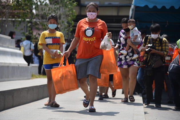April 23, 2020, Bangkok, Thailand: People walk back home after receiving items from Thai monks during the event..Wat Rakhang Khositaram a Thai monk monastery gives to the general public and medical staff of Siriraj Hospital. Due to the shutdown following the Covid-19 outbreak, many people are living without income and economically affected. Bangkok Thailand - ZUMAs197 20200423_zaa_s197_106 Copyright: xYuttachaixKongprasertx