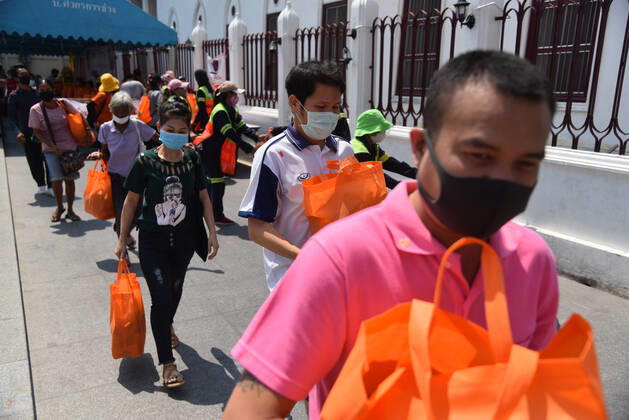 April 23, 2020, Bangkok, Thailand: People walk back home after receiving items from Thai monks during the event..Wat Rakhang Khositaram a Thai monk monastery gives to the general public and medical staff of Siriraj Hospital. Due to the shutdown following the Covid-19 outbreak, many people are living without income and economically affected. Bangkok Thailand - ZUMAs197 20200423_zaa_s197_110 Copyright: xYuttachaixKongprasertx