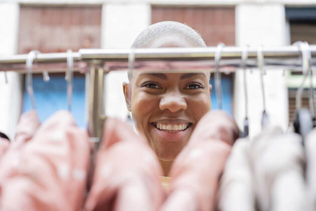 Portrait of happy woman behind clothes rail model released Symbolfoto AFVF05917