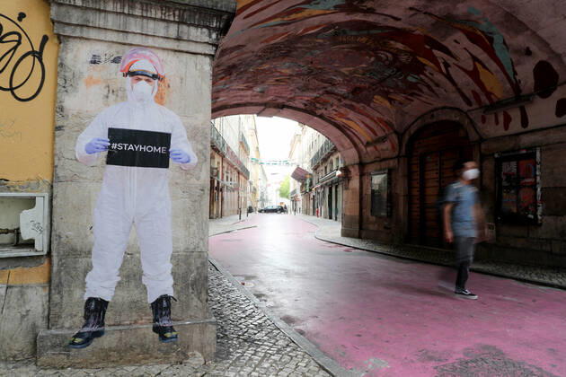 Coronavirus in Portugal, Eindrücke aus Lissabon April 23, 2020, Lisbon, Portugal: A man with a face mask walks by a paper figure of a firefighter dressed in protective gear and holding a stay at home sign on a wall as the spread of the COVID-19 Coronavirus disease continues, in Lisbon, Portugal on April 23, 2020. With 820 dead and 22353 confirmed cases the country is feeling the impact of the COVID-19 Coronavirus pandemic. Lisbon Portugal - ZUMAf123 20200423_zap_f123_001 Copyright: xPedroxFiuzax