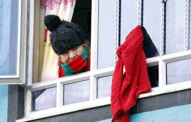 Coronavirus in Kolumbien, Eindrücke aus Bogota A woman who put a red cloth in his window to indicate that she has no money or food, observes the workers of the Mayor s Office who deliver markets to vulnerable populations in the south of Bogota, Colombia, 23 April 2020. Officials from the Mayor s Office of the Colombian capital delivered markets in the Molinos sector, a poor neighborhood in the south of the city where its inhabitants have been economically affected by the national quarantine against the coronavirus. Bogota City Hall distributes markets to vulnerable population !ACHTUNG: NUR REDAKTIONELLE NUTZUNG!  Copyright: xMauricioxDuenasxCastanedax AME5338 20200424-637232923998985665