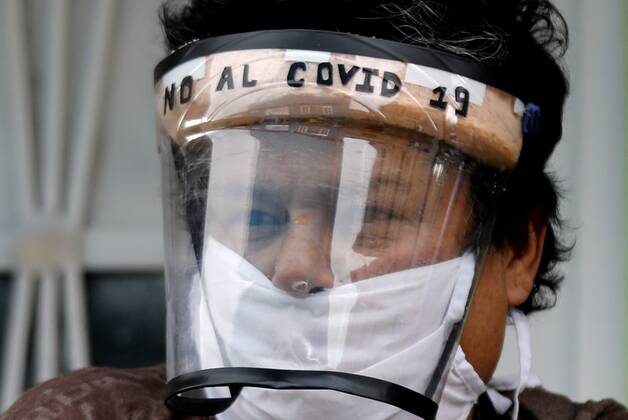 Coronavirus in Kolumbien, Eindrücke aus Bogota A woman protected with a mask leaves her house to observe the workers of the Mayor s Office who deliver markets to vulnerable populations in the south of Bogota, Colombia, 23 April 2020. Officials from the Mayor s Office of the Colombian capital delivered markets in the Molinos sector, a poor neighborhood in the south of the city where its inhabitants have been economically affected by the national quarantine against the coronavirus. Bogota City Hall distributes markets to vulnerable population !ACHTUNG: NUR REDAKTIONELLE NUTZUNG!  Copyright: xMauricioxDuenasxCastanedax AME5356 20200424-637232924639901273