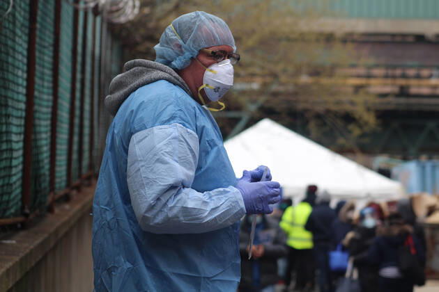 Coronavirus in den USA, Eindrücke aus New York April 23, 2020, New York, New York, USA: This healthcare worker, all protected in blue, a test kit in hands, stands at the entrance to one of the new five walk-in Coronavirus testing sites open in the Bronx, a line of residents stretching behind him. Five more sites will open across New York City next week while research has revealed that 1 in 5 people tested in New York City had antibodies for the COVID-19. New York USA - ZUMAb197 20200423_znp_b197_001 Copyright: xMariexLexBlex