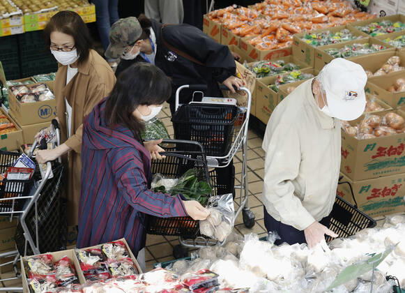 New coronavirus People wearing face masks shop at a supermarket in Tokyo on April 24, 2020, amid the spread of the new coronavirus. Tokyo Gov. Yuriko Koike has requested residents limit their grocery store visits to once every three days as part of steps to prevent supermarkets from becoming overcrowded. 