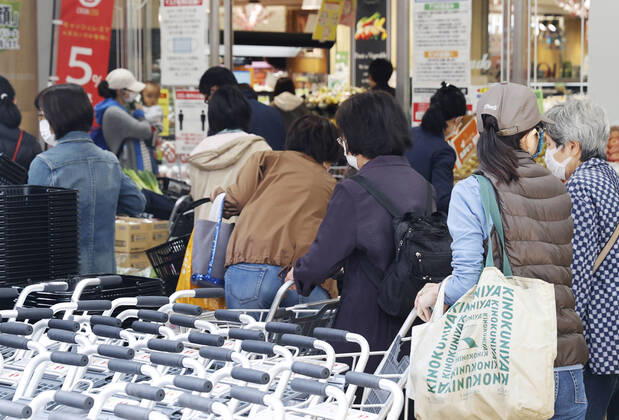 New coronavirus People wearing face masks shop at a supermarket in Tokyo on April 24, 2020, amid the spread of the new coronavirus. Tokyo Gov. Yuriko Koike has requested residents limit their grocery store visits to once every three days as part of steps to prevent supermarkets from becoming overcrowded. 