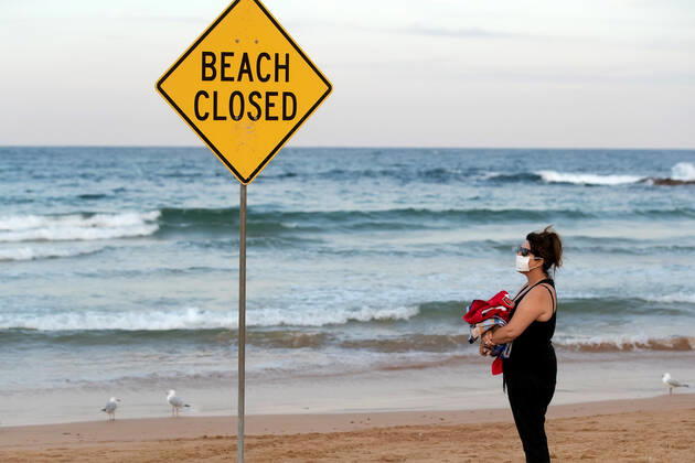 SYDNEY, AUSTRALIA - APRIL 23: Woman with face mask contemplates a swim on a closed Dee Why beach due to COVID 19 on 23 April, 2020 in Sydney, Australia. (Photo by Speed Media Icon Sportswire)