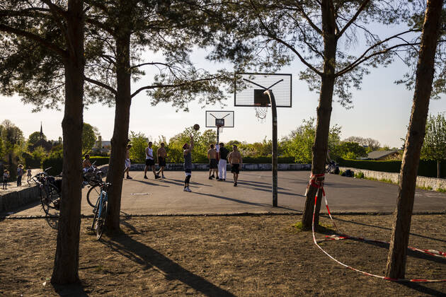 Junge Maenner spielen Basket auf einem Spielplatz in Berlin am 23. April 2020. Ab gestern koennen laeden unter 800 qm, Buchhandlucngen und Autosalons wieder oeffnen mit Einhanltung von Hygiene und Distanzvorschriften. Heute waren spuerbar mehr Menschen unterwegs. Coronavirus in Berlin