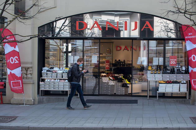 Coronavirus in Litauen, Eindrücke aus Vilnius (200424) -- VILNIUS, April 24, 2020 (Xinhua) -- A man walks past a shop in Vilnius, capital of Lithuania, April 23, 2020. The government of Lithuania on Wednesday extended the nationwide quarantine restrictions until May 11 with the easing measures such as reopening of all shops and shopping malls from Thursday. Th new measures also included letting outdoor cafes, hairdressing, beauty parlors, libraries and museums to resume operation from the start of the next week. (Photo by Alfredas Pliadis Xinhua) LITHUANIA-VILNIUS-COVID-19 