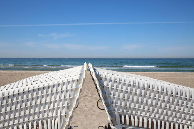 Nichts geht mehr am Meer: Blick am Donnerstag (23.04.2020) auf das fast leere Ostseebad Warnemünde. Die Urlaubsregionen des Landes Mecklenburg Vorpommern sind infolge der Corona – Krise nach wie vor für Touristen gesperrt. Das wirkt sich mehr und mehr auf die wirtschaftliche Bilanz der Tourismuswirtschaft aus. So fehlen unter anderem die Einnahmen aus der Kurtaxe, den Parkgebühren, den Gaststätten und der Fahrgastschifffahrt. Das nagt bei einigen Unternehmen bereits an der Existenz. Denn die Einheimischen können die Einnahmen aus dem Tourismus nicht auffangen. Das zeigte sich insbesondere auch im Verlauf des Tages in dem Urlaubsort an der Ostseeküste. Dort waren nur wenige Menschen auf den Straßen unterwegs. Im Bild zusammengerückte Strandkörbe