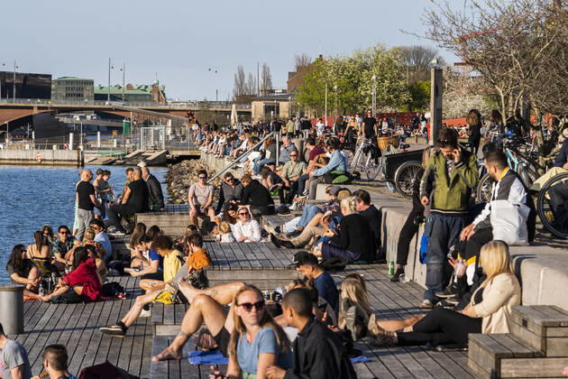 Koebenhavnere nyder det varme foraarsvejr paa Island Brygge i Koebenhavn torsdag den 23. april 2020.Trods kravet om at holde afstand samles grupper af unge i stigende grad i parker og paa pladser. Rigspolitichef varsler forbud mod at saette sig visse steder.Det skriver Ritzau, fredag den 24. april 2020. ** OBS billedet et optaget med et teleobjektiv og afstanden mellem personer paa billedet kan opfattes mindre en den reelt er. **. . , Denmark Copyright: MartinxSylvestx cop777 spdk20200424-092042-L
