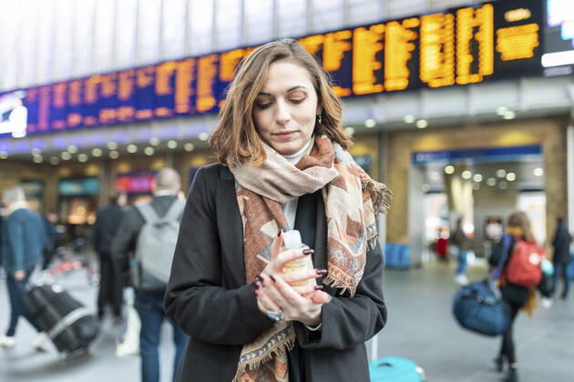 Woman using sanitising hand gel at train station model released Symbolfoto  WPEF02798