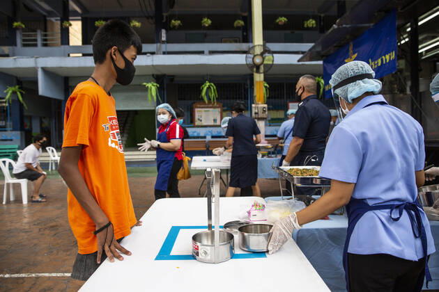 Coronavirus in Thailand, Essensausgabe an Bedürftige in Bangkok April 24, 2020, Bangkok, Thailand: A young boy waits to receive free meals to help combat the loss of income due to COVID-19 at the Wat Don Muang School in Bangkok, Thailand. 300 families accepted free food, with an estimated 1500 being fed based on average family size. The food giveaway was facilitated by the Thai Airforce to ensure proper social distancing measures. Bangkok Thailand - ZUMAm249 20200424_zip_m249_012 Copyright: xAndrexMalerbax