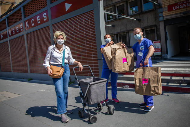 Coronavirus in Frankreich, Marie Chavarot versorgt medizinisches Personal in Paris mit Lunchboxen (200424) -- PARIS, April 24, 2020 (Xinhua) -- Two medical staff receive lunch boxes from Marie Chavarot outside Cochin hospital during the lockdown to curb the spread of COVID-19 in Paris, France, April 23, 2020. Marie Chavarot is a self-taught chef who created her culinary laboratory four years ago. Since April 1, she has been cooking four days a week for the medical staff of the Cochin hospital and delivers lunch boxes of culinary creations to them to thank them in her own way. (Photo by Aurelien Morissard Xinhua) FRANCE-PARIS-COVID-19-COOK FOR MEDICAL STAFF 