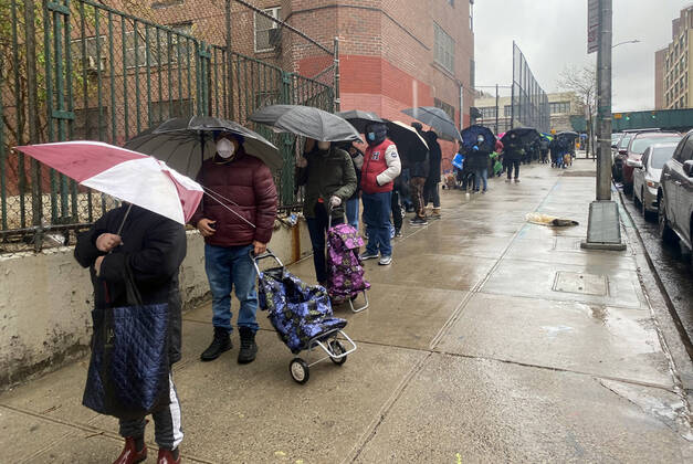 NEW YORK, NY- APRIL 24: New Yorkers line up in the Rain at food distribution point with paper bags donated by Staples at Roberto Clemente School during the coronavirus pandemic in West Harlem on April 24, 2020 in New York City. Copyright: xRainmakerxPhotos MediaPunchx