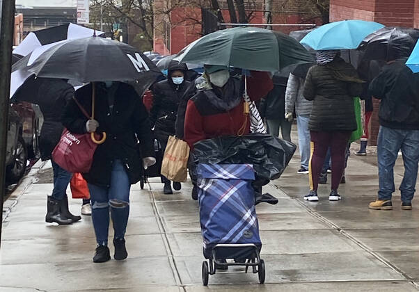NEW YORK, NY- APRIL 24: New Yorkers line up in the Rain at food distribution point with paper bags donated by Staples at Roberto Clemente School during the coronavirus pandemic in West Harlem on April 24, 2020 in New York City. Copyright: xRainmakerxPhotos MediaPunchx