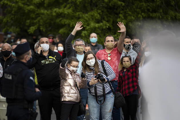 Demonstranten winken ueber die Grenze im Rahmen des Protestes gegen die geschlossene Grenze zwischen Zgorzelec und Goerlitz, 24.04.2020. Zur Eindaemmung des Coronaviruses haben unter anderem Polen und Tschechien Mitte Maerz die Grenzen nach Deutschland geschlossen. Hintergrund des Protestes sind die aktuellen Einschraenkungen fuer Arbeiter, die normalerweise taeglich nach Deutschland pendeln, jetzt aber nach Wiedereinreise nach Polen in zweiwoechige Quarantaene muessten. Ausserdem sind grenzuebergreifende, familiaere Kontakte durch die geschlossenen Grenzen schwer moeglich. Goerlitz Deutschland